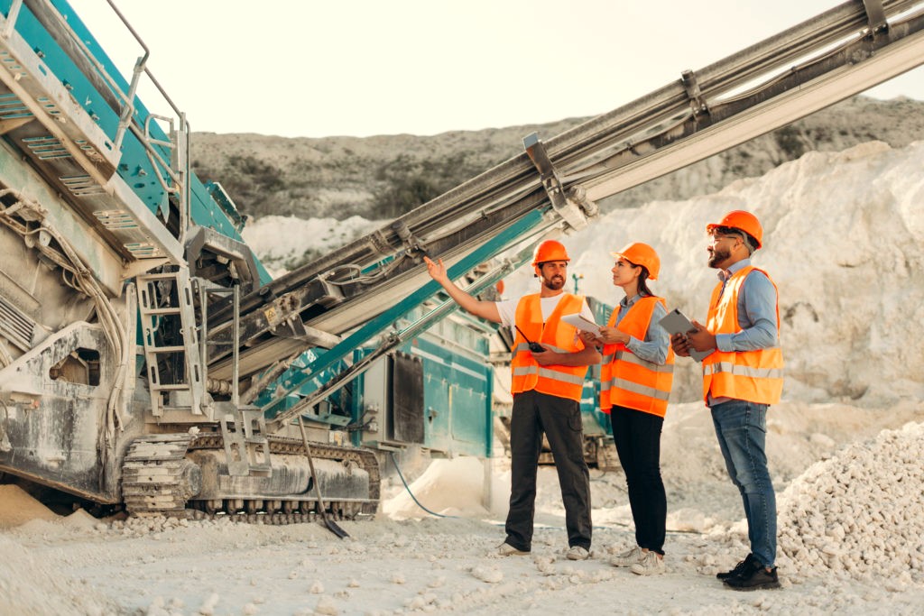 A mining crew talking through the plan in front of the crusher