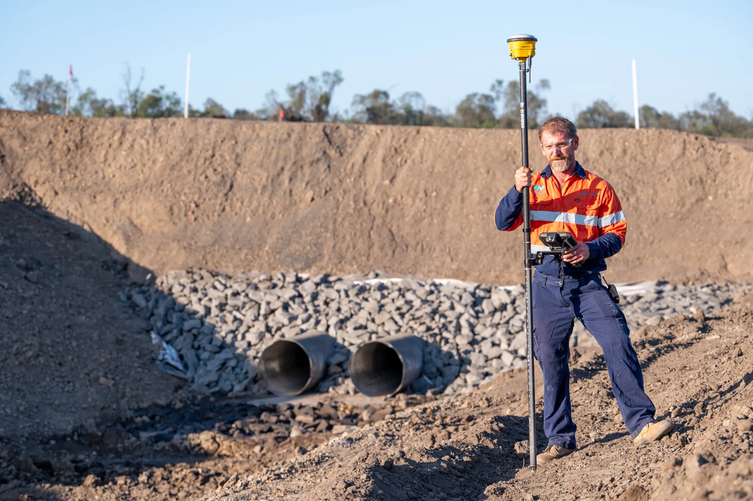 A site surveyor checking records on a handheld controller